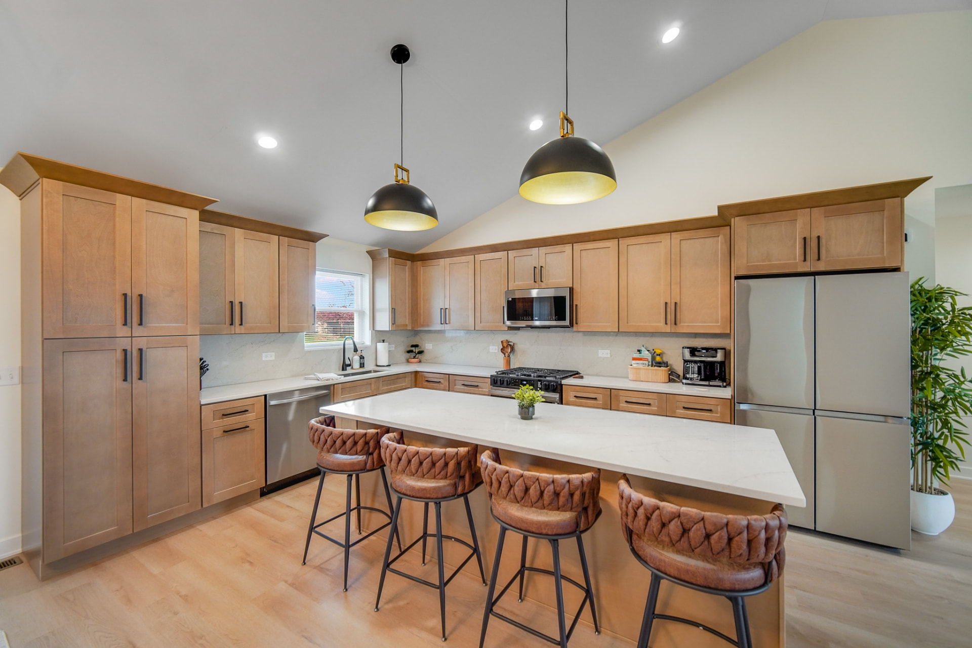 New construction kitchen with maple shaker cabinetry and quartz island