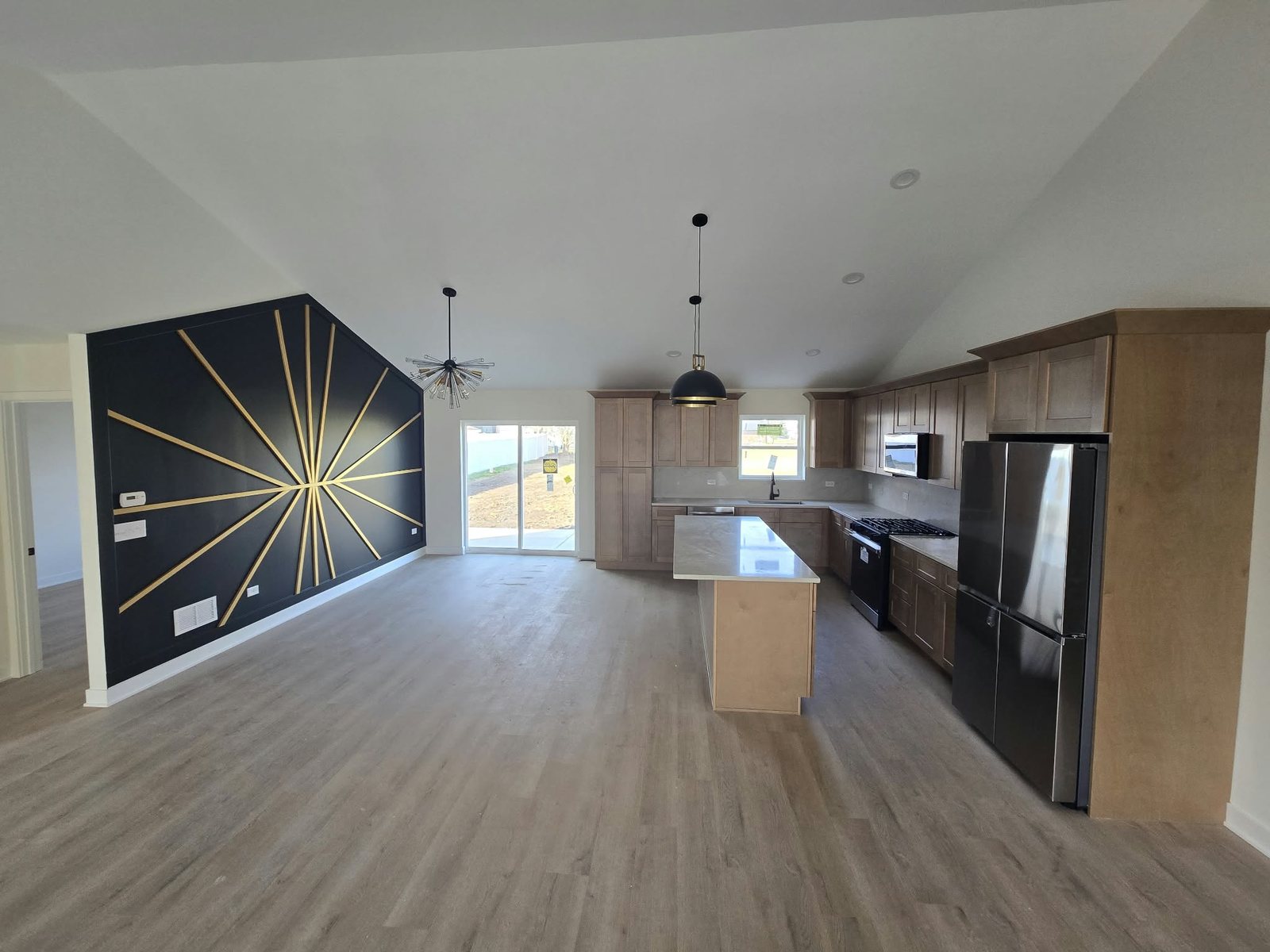 Finished vaulted great room and maple kitchen with quartz island in a Manteno new construction home