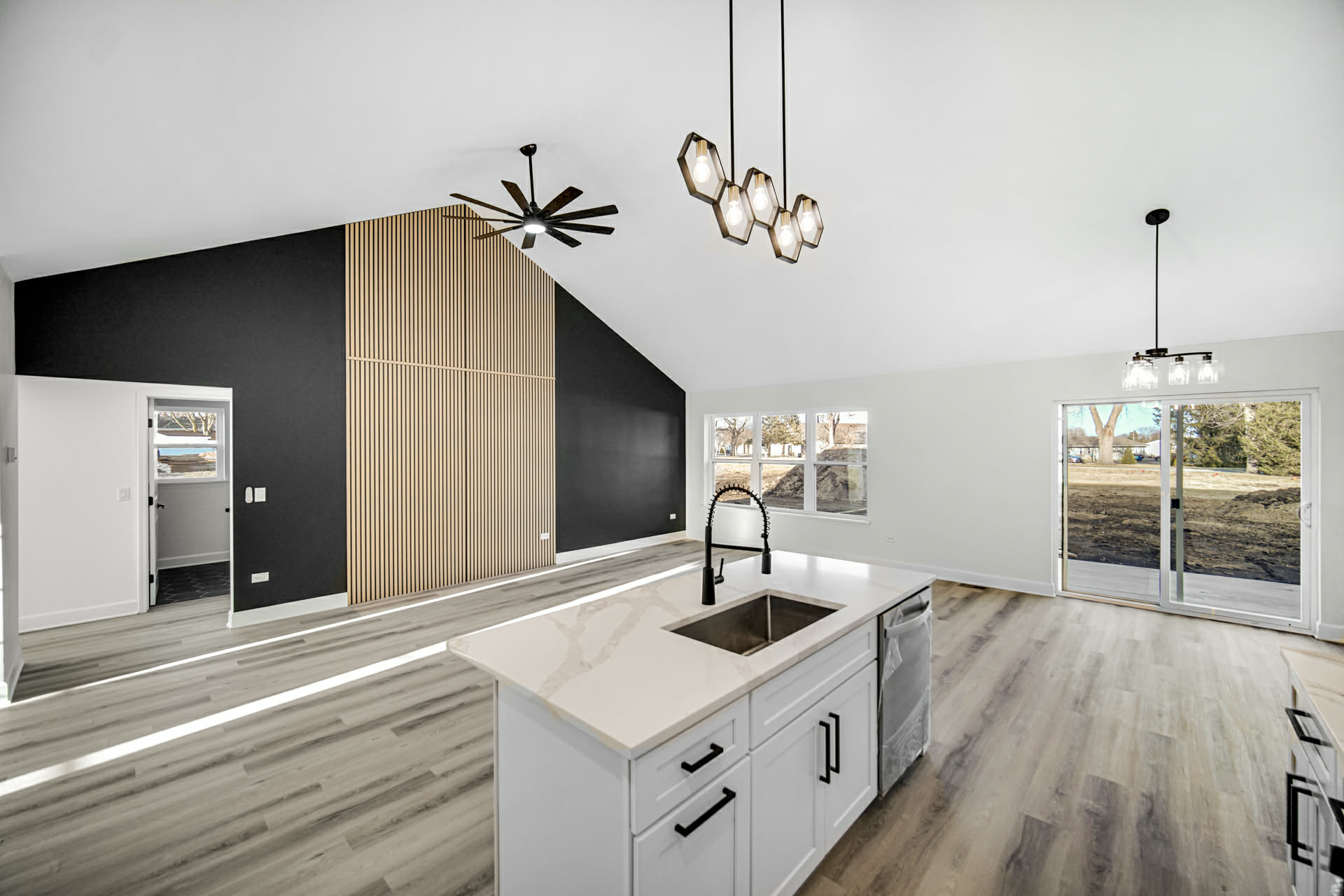 Charcoal accent wall with a custom oak slat feature panel in the vaulted living area