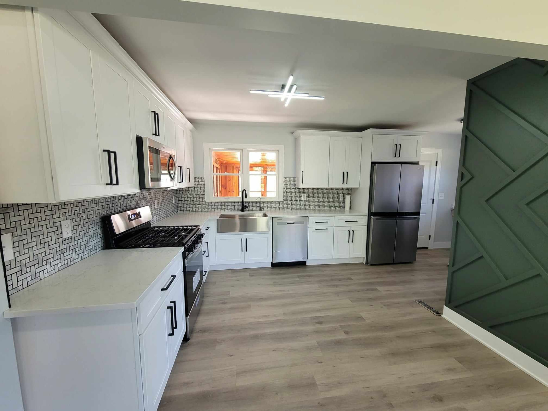Wide view of the remodeled Mokena kitchen with farmhouse sink and black hardware