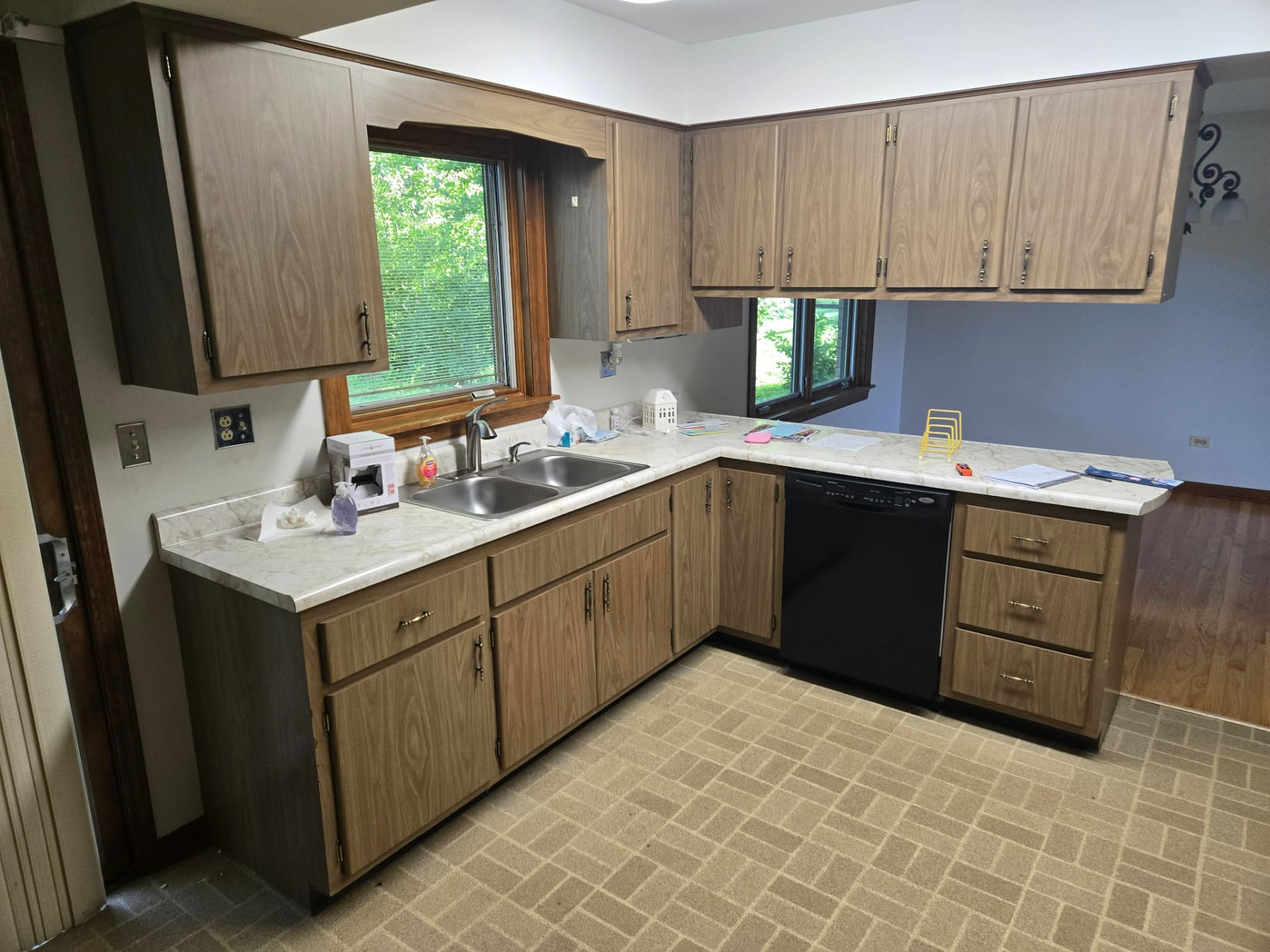 Before: closed-off kitchen with 1980s laminate cabinets, marble-look laminate tops, and brick-pattern vinyl floor
