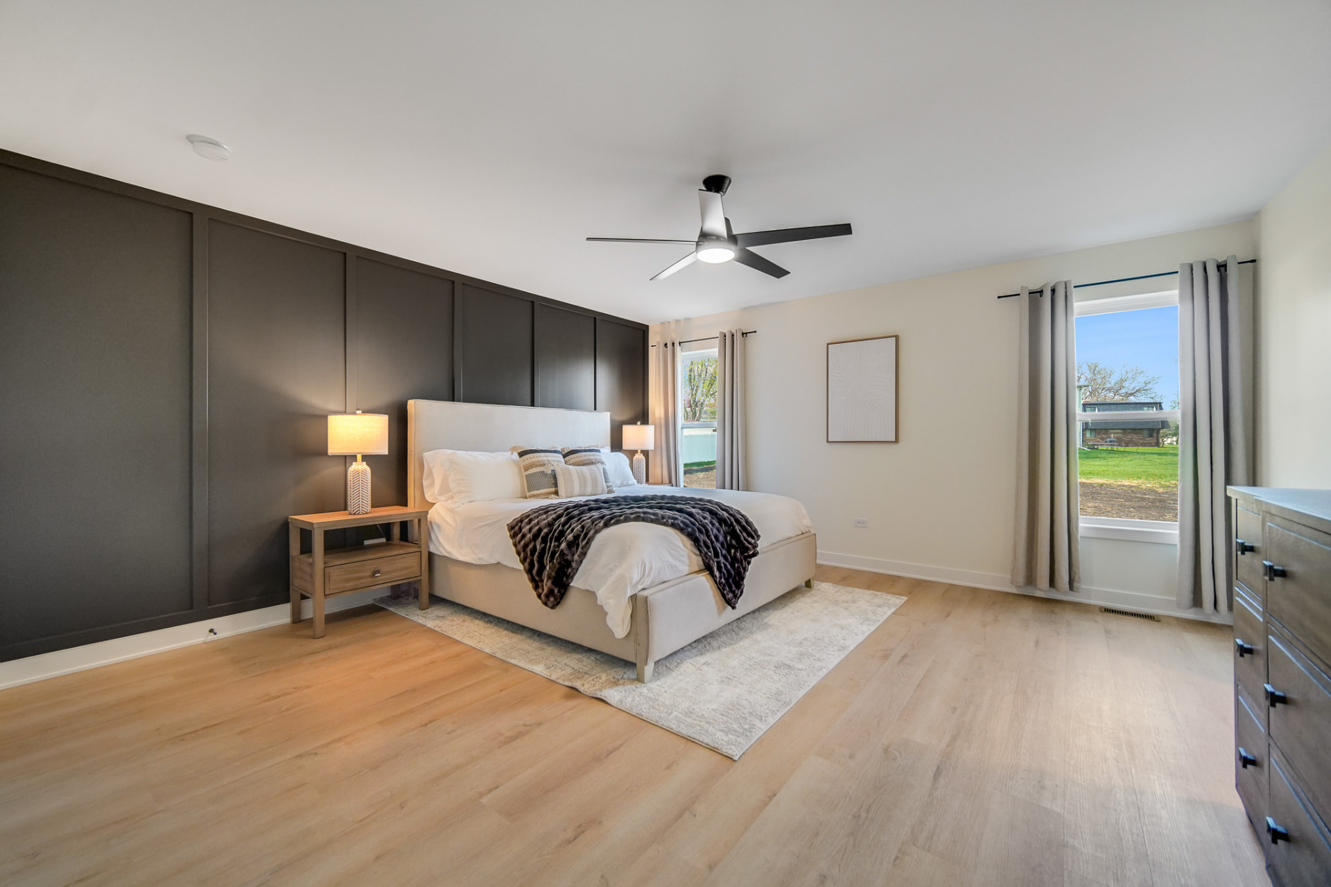 Primary bedroom with paneled charcoal accent wall