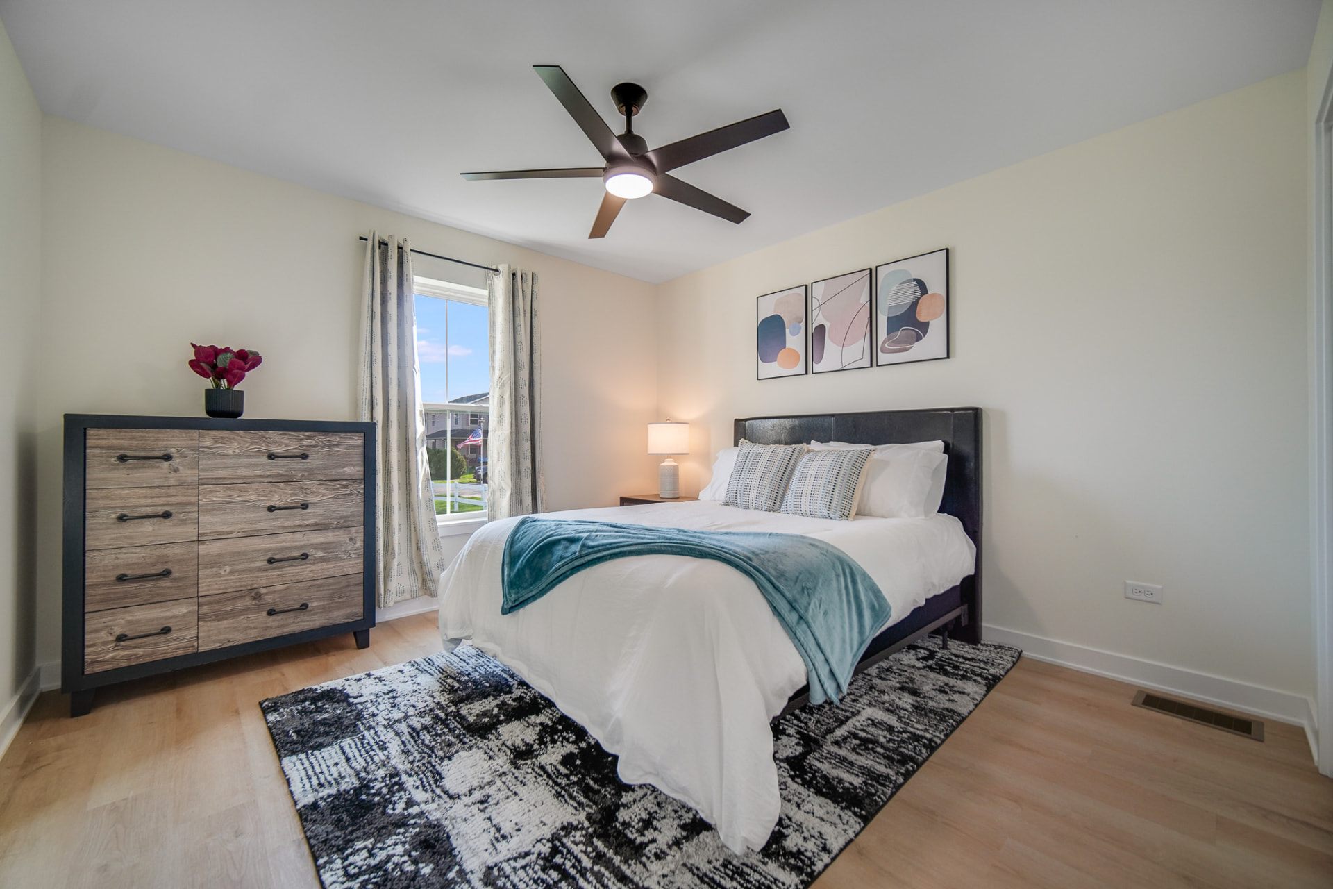 Bedroom with vaulted ceiling fan and natural light