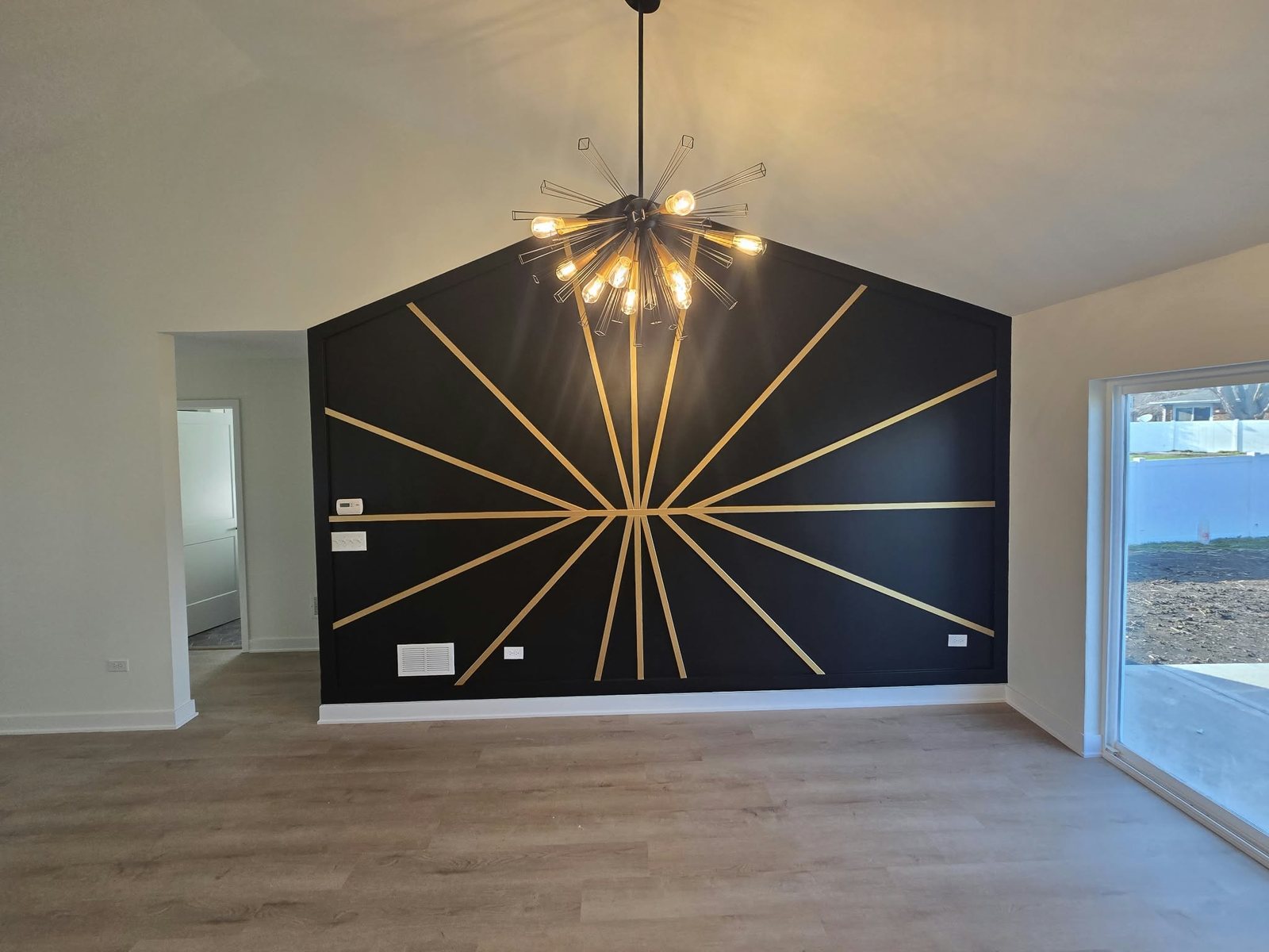 Finished black and gold sunburst accent wall under a vaulted ceiling